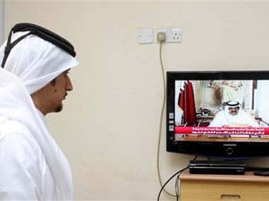 A man watches a televised address by the Qatar Emir announcing his decision to step aside in favour of his son: AP