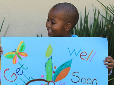 A young boy from Othandweni Community Center holds a placard wishing former South African President Nelson Mandela a prompt recovery. AP