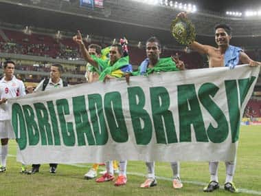 Players of Tahiti wave to fans holding a sign reading in Portuguese 