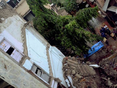  People looking at the debris after a three- storey building collapsed at Mahim in Munbai on Tuesday. PTI