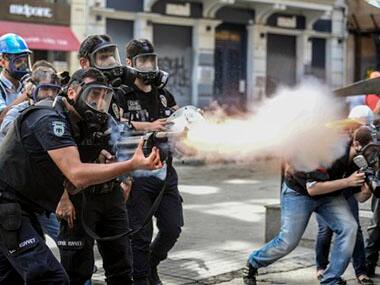 Police fire tear gas as riot police spray water cannon at demonstrators. AP photo