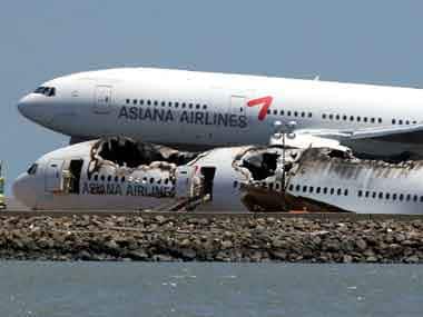 An Asiana Airlines flight lands next to the wreckage of Asiana Airlines flight 214 as it sits on runway 28L at San Francisco International Airport on 9 July 2013 in San Francisco, California. AFP