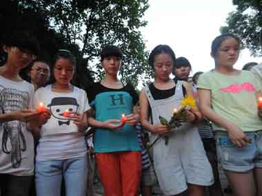 Teenage girls holding candles and flowers in Jiangshan, China’s eastern Zhejiang province to mourn two Chinese girls killed in a South Korean passenger jet crash in San Francisco. AFP 