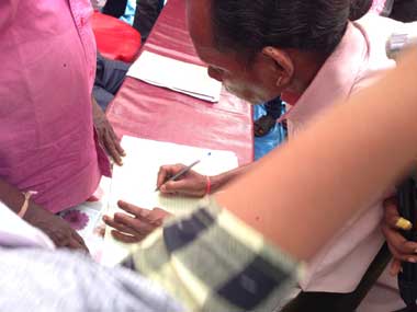 Village head signs the palli sabha resolution after 3.5 hours of high drama. Image courtesy: Jay Mazoomdar