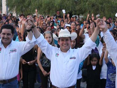 Benjamin Medrano, center, raises his arms with other unidentified people during a campaign event in Chichimequillas, Mexico: AP