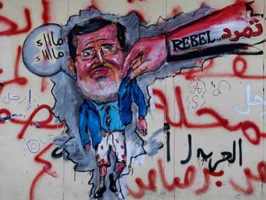 Graffiti depicting Egypt's Islamist President Mohammed Morsi with an Arabic writing that reads: "Leave, right" covers an outer wall of the presidential palace in Cairo, Egypt. AP