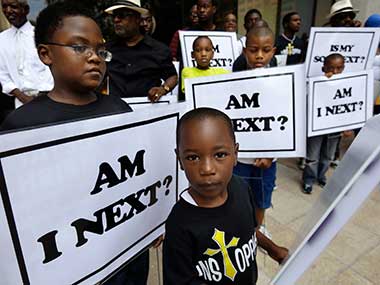 Alvin Duplessis, 10, left, and Thomas McGriff, 5, foreground, hold signs with others from the Watson Memorial Teaching Ministries Church of New Orleans, at a rally held in reaction to the recent George Zimmerman acquittal in New Orleans. AP