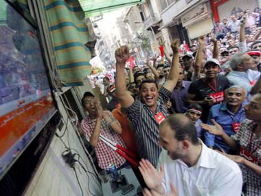 Opponents of Egypt's Islamist President Mohammed Morsi celebrate as they watch the news at a coffee shop near Tahrir Square in Cairo, Egypt. AP