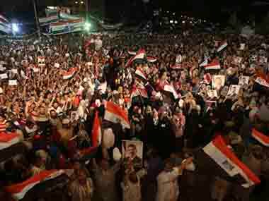 Supporters of ousted Egypt’s President Mohammed Morsi, hold his portraits and wave Egyptian flags as they shout slogans during a demonstration after the Iftar prayer. AP