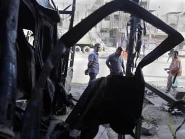 People inspect the aftermath of a car bomb attack at a convenience store in the Shaab neighborhood of Baghdad. AP