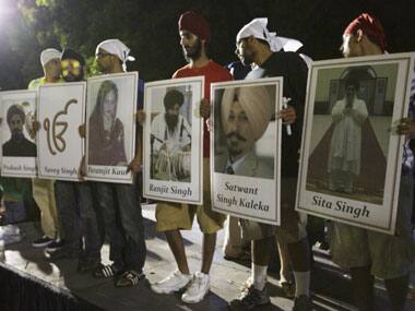 Relatives of the Wisconsin gurdwara shooting victims hold up their pictures. Reuters.