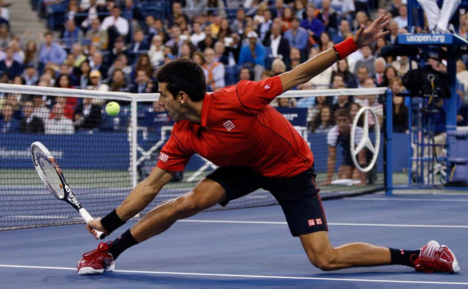 Novak Djokovic of Serbia reaches down to hit a return to Rafael Nadal of Spain during their men's final match at the U.S. Open tennis championships in New York, September 9, 2013. REUTERS