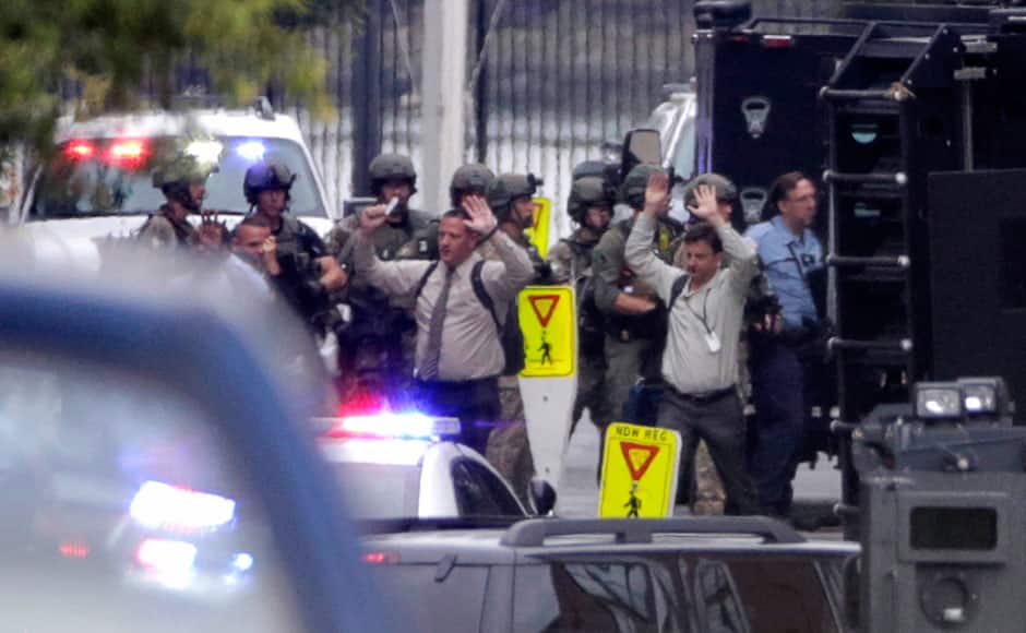 Evacuees raise their hands as they are escorted from the scene of a shooting at the Washington Navy Yard in Washington, September 16, 2013. Several people were killed and others injured when at least one gunman opened fire at the U.S. Navy Yard in Washington D.C. on Monday, authorities said. One Navy official said that four people had died and eight others were injured, but other officials suggested caution over those numbers saying the situation was in flux. REUTERS/Jason Reed 