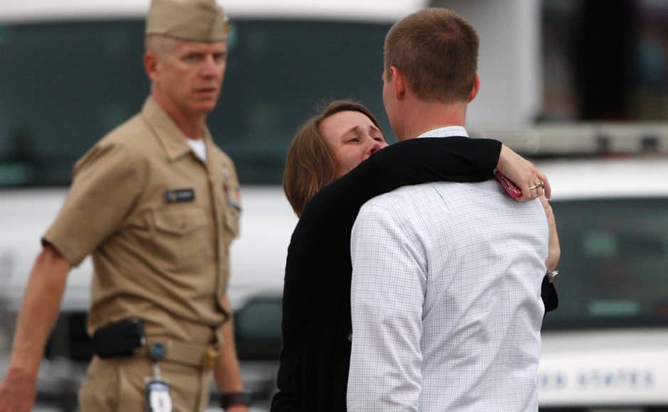 A woman weeps as she is reunited with her husband, who was one of hundreds of Navy Yard workers evacuated to a makeshift Red Cross shelter after a shooting, at the Nationals Park baseball stadium near the affected naval installation in Washington, September 16, 2013. A 34-year-old man opened fire at the U.S. Navy Yard on Monday in a shooting that left 13 people dead, including the gunman, not far from the U.S. Capitol and the White House, officials said. The suspect was identified by the FBI as Aaron Alexis of Fort Worth, Texas. Washington D.C. police chief Cathy Lanier told reporters that Alexis 