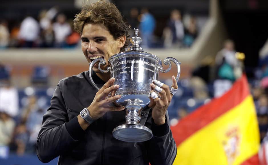Rafael Nadal of Spain bites his trophy after defeating Novak Djokovic of Serbia in their men's final match at the U.S. Open tennis championships in New York, September 9, 2013. REUTERS
