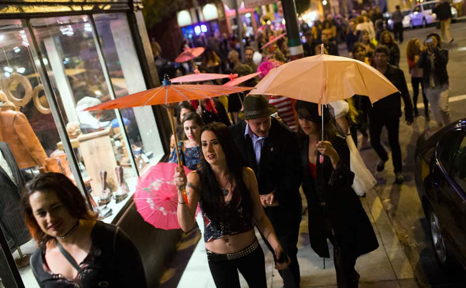 Participants hold up umbrellas during a funeral procession to symbolize the closure of Lusty Lady strip club in San Francisco, California September 1, 2013. United States' first and only unionized, employee-owned strip club shuts its doors on September 2 after its landlord refused to negotiate on a lower rent, local media reported. Picture taken September 1, 2013. REUTERS/Stephen Lam