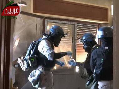 An screen grab taken from a video distributed by Arbeen Unified Press office allegedly shows UN arms experts collecting samples as they inspect the site where rockets had fallen in Damascus' eastern Ghouta suburb. AFP/YouTube/Arbeen Unified Press office 