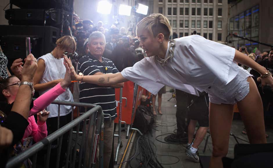 Singer Miley Cyrus high fives a fan as she performs on NBC's 'Today' show in New York, October 7, 2013. REUTERS/Carlo Allegri 