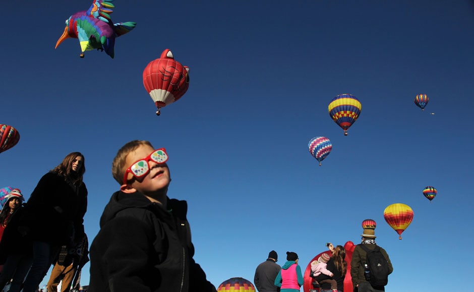 Balloons in their eyes: A little boy enthralled as more than 500 balloons of all shapes and sizes lift off in two stages: Reuters Balloons in their eyes: A little boy enthralled as more than 500 balloons of all shapes and sizes lift off in two stages: Reuters