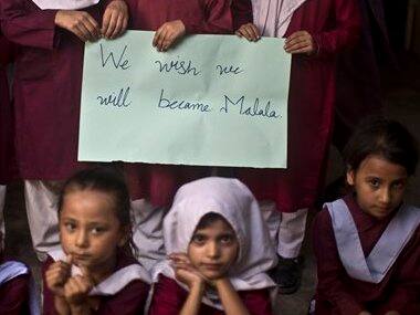 Pakistani school children hold a sign during a special class to commemorate the anniversary of Malala Yousufzai's shooting. AP image