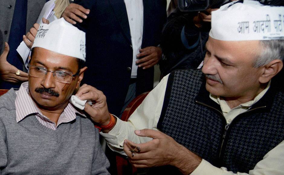 Aam Aadmi Party leader Manish Sisodiya cleans the face of party convener Arvind Kejriwal after a man threw black ink at him at a press conference in New Delhi on Monday. PTI 