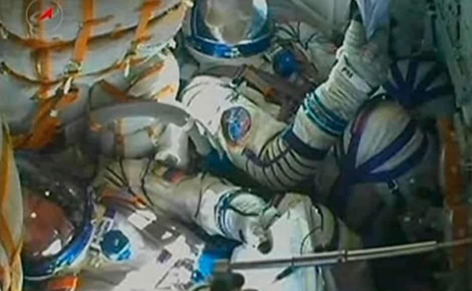 International Space Station (ISS) crew members are seen in the capsule of the Soyuz rocket November 7, 2013 in this still image taken from NASA TV footage. A three-man crew successfully blasted off into space with the Olympic torch on Thursday, ready to take it on its first space walk in what they said would be a 