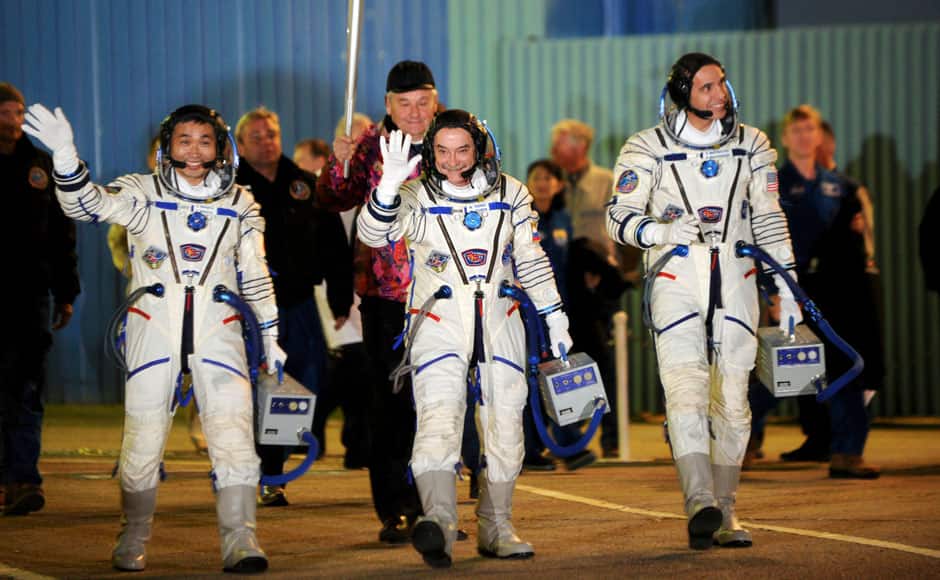 International Space Station (ISS) crew members, Japanese astronaut Koichi Wakata (L), Russian cosmonaut Mikhail Tyurin (C) and NASA astronaut Rick Mastracchio, wave after donning space suits shortly before before the blast off to ISS, at the Baikonur cosmodrome November 7, 2013. They will have the Sochi 2014 Winter Olympic Games torch with them when they blast off for the ISS from the Baikonur cosmodrome, which Moscow rents from Kazakhstan. REUTERS