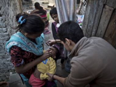A polio worker delivers polio drops to children in Pakistan. AP 