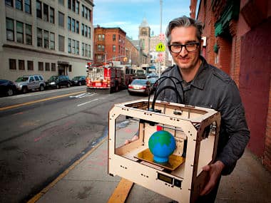 Bre Pettis, co-founder and CEO of Makerbot Industries LLC, is pictured in front of Makerbot Industries LLC manufacturing location, the Botcave, with a three-dimensional printer 