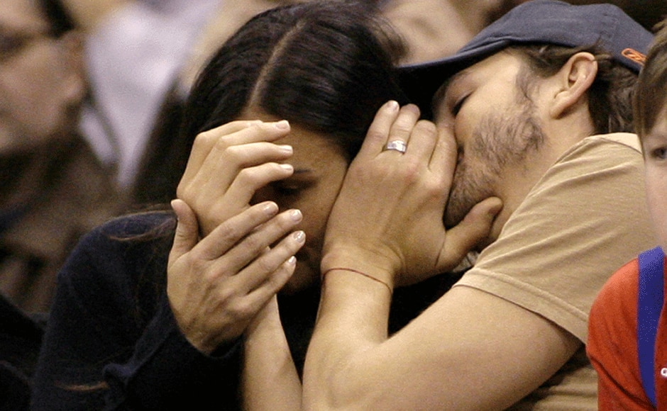 Actor Ashton Kutcher (R) whispers to his wife, actress Demi Moore, as they attend the NBA basketball game between the Cleveland Cavaliers and the Los Angeles Clippers in Los Angeles, California January 13, 2007.