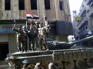 Soldiers loyal to Syria's President Bashar al-Assad with their weapons stand atop a military tank at Jouret al-Shaiyah neighborhood in Homs city. Reuters