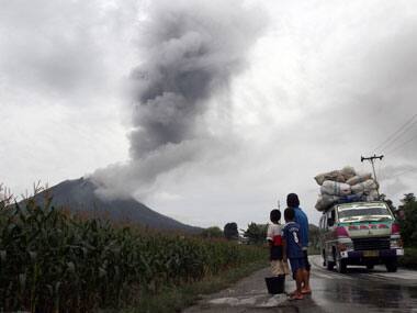 Villagers watch as Mount Sinabung spews ash at Sibintun village in Karo district, Indonesia's North Sumatra province. Reuters