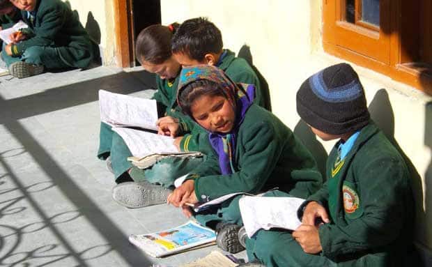 The students of Himalayan Buddhist Culture School sit outside their classrooms, soaking up the sun for comfort and better concentration.
