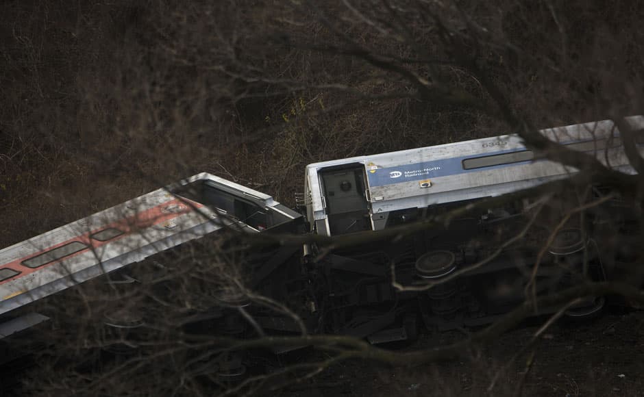 Train cars are seen at the site of a Metro-North train derailment in the Bronx borough of New York December 1, 2013. At least four people were killed and 63 injured, including 11 critically, when the suburban train derailed, with at least five cars from the Metro-North train sliding off the tracks, officials said. REUTERS