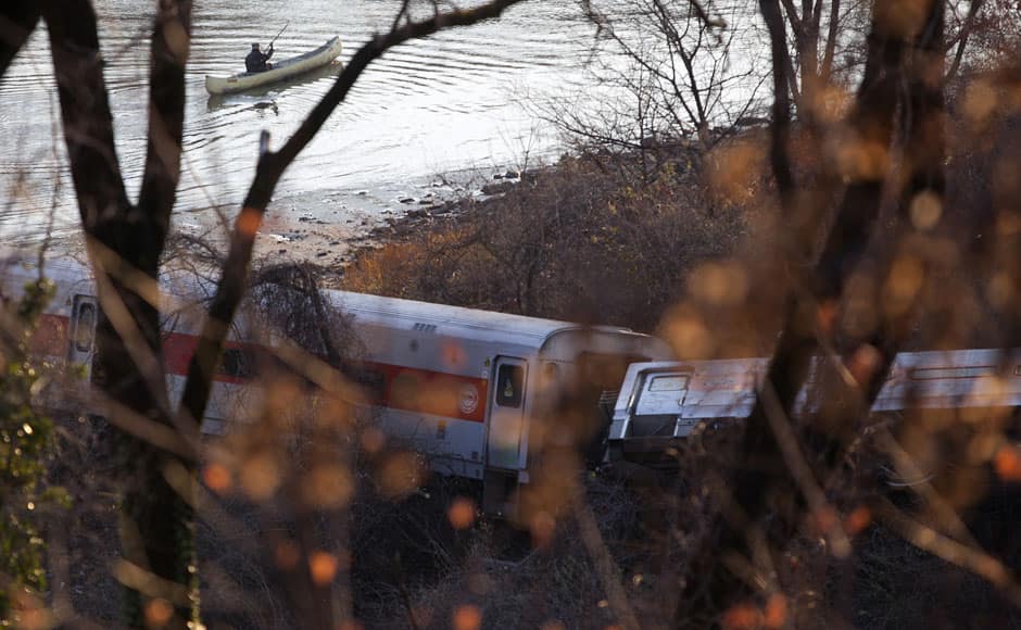 A man in a kayak paddles past the site of a Metro North train derailment in the Bronx borough of New York December 1, 2013. Commuters from New York City's northern suburbs braced for travel delays on Monday morning following a seven-car train derailment that killed four people and injured 11 critically. The Manhattan-bound commuter train ran off the tracks while rounding a sharp curve in the Bronx. REUTERS