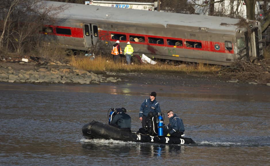 New York Police Department officials use a boat to search the waters around the site of a Metro-North train derailment in the Bronx borough of New York December 1, 2013. A suburban New York train derailed on Sunday, killing four people and injuring 63, including 11 critically, when all seven cars of a Metro-North train ran off the tracks on a sharp curve, officials said. The crash happened at 7:20 a.m. (1220 GMT) about 100 yards (metres) north of Metro North's Spuyten Duyvil station in the city's Bronx borough, said Metro North spokesman Aaron Donovan. REUTERS