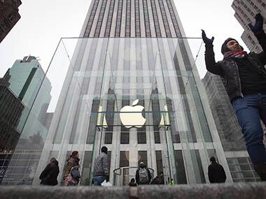 A man poses for a photo in front of the Apple store on 5th Avenue in New York. Reuters