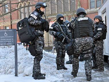 Tactical police assemble outside a building at Harvard University in Cambridge, Mass., Monday, Dec. 16, 2013. Four buildings on campus were evacuated after campus police received an unconfirmed report that explosives may have been placed inside, interrupting final exams. AP
