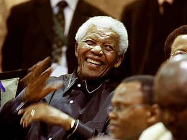 South Africa's former president Nelson Mandela gestures from the gallery at the opening of parliament in Cape Town February 11, 2010. Chanting 