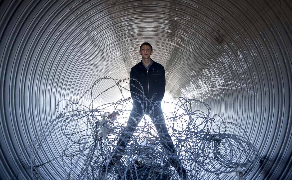 Gay rights activist Vladislav Slavsky poses for a photograph in a construction pipe at the beach in Sochi, south western Russia October 21, 2013. This year President Vladimir Putin signed a law banning the spread of 