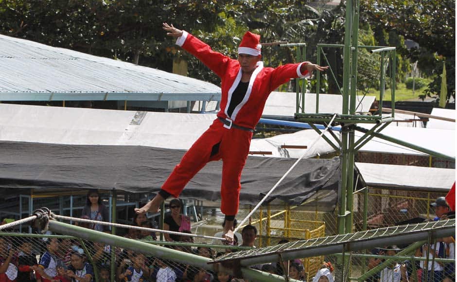 Jonald Libres, 28, walks on a tight rope over live crocodiles while wearing a Santa Claus costume as part of performances for the Christmas Yuletide season at a crocodile farm in Pasay city, metro Manila in the Philippines. Reuters image