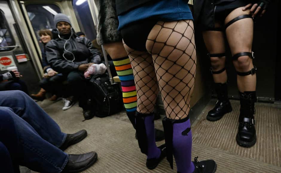 Passengers without pants ride a train during the 