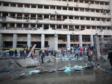Egyptian police officers and firefighters gather at the Egyptian police headquarters after a blast in downtown Cairo on Friday. AP