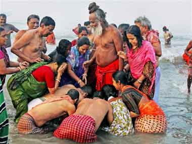 Pilgrims seeks blessings from a Sadhu after a holy dip at Sagar Island on the occasion of Makar Sankranti on Tuesday. PTI 