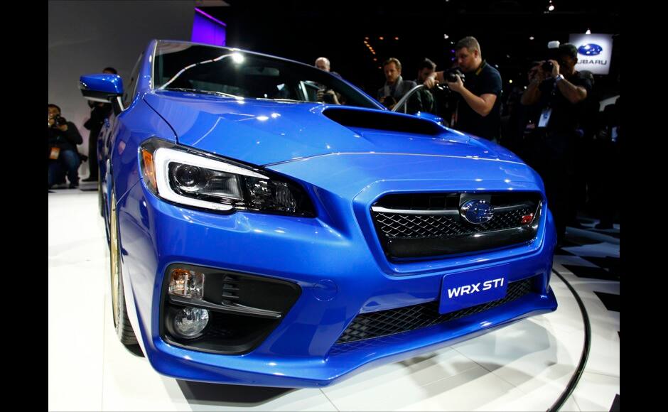 Members of the media take pictures of a Subaru WRX STI as it is displayed during the press preview day of the North American International Auto Show in Detroit, Michigan January 14, 2014. REUTERS