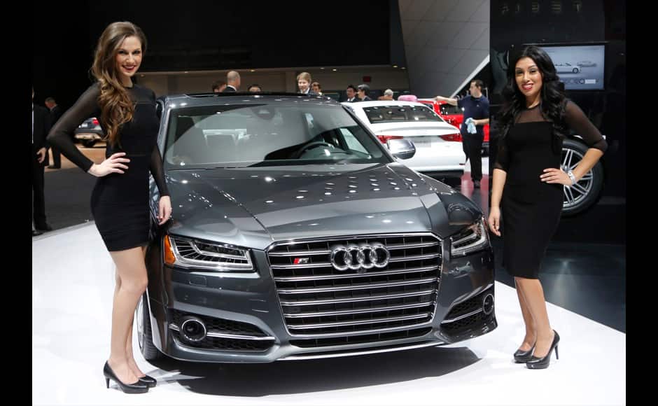 Models Kristina Martin (L) and Cassandra Ramos pose next to a 2014 Audi S8 during the press preview day of the North American International Auto Show in Detroit, Michigan January 14, 2014. REUTERS