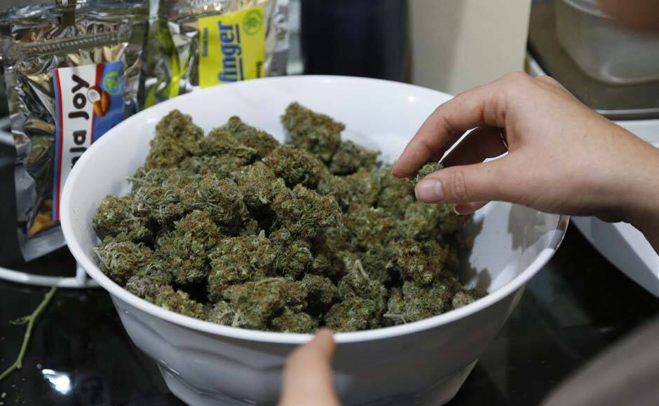 Danielle Hackett prepares marijuana buds for sale at BotanaCare in Northglenn, Colorado December 31, 2013. Proprietors of the first marijuana retailers licensed to sell pot for recreational use in Colorado, including BotanaCare, were busy rolling joints and stocking shelves with their leafy merchandise on Tuesday, ahead of a New Year's Day grand opening that marks a new chapter in America's drug culture. REUTERS/Rick Wilking (UNITED STATES - Tags: BUSINESS SOCIETY POLITICS DRUGS) - RTX16YCH