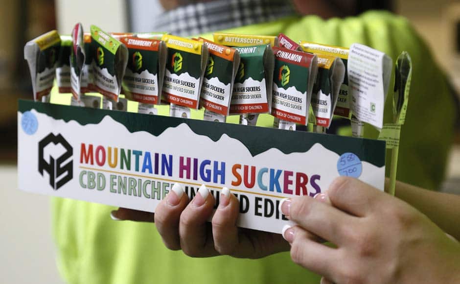 An employee brings out a display of drug-infused candies at the Botana Care marijuana store just before opening the doors to customers for the first time in Northglenn, Colorado January 1, 2014. Marijuana proprietors in Colorado are pioneers in a new chapter of America's drug culture that marks the first time cannabis will be legally produced, sold and taxed under a special system many states have long established for alcohol sales. REUTERS/Rick Wilking (UNITED STATES - Tags: BUSINESS SOCIETY POLITICS HEALTH DRUGS) - RTX16Z9G