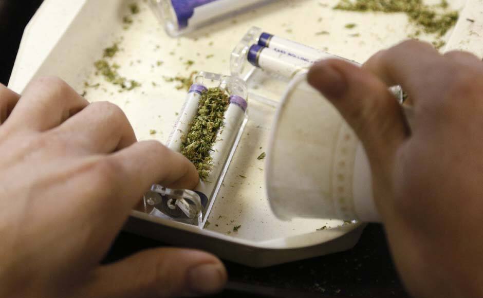 A worker rolls marijuana joints for sale at the Botanacare marijuana store ahead of their grand opening on New Year's day in Northglenn, Colorado December 31, 2013. The world's first state-licensed marijuana retailers, catering to Colorado's newly legal recreational market for pot, are stocking their shelves ahead of their January 1, 2014, grand opening that supporters and detractors alike see as a turning point in America's drug culture. REUTERS/Rick Wilking (UNITED STATES - Tags: SOCIETY DRUGS) - RTX16YDJ