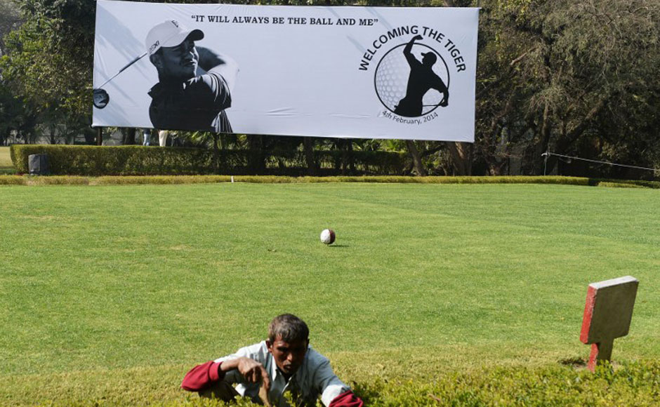A gardener works on a hedge in front of a billboard featuring images of US golfer Tiger Woods at The Delhi Golf Club in New Delhi. AFP A gardener works on a hedge in front of a billboard featuring images of US golfer Tiger Woods at The Delhi Golf Club in New Delhi. AFP